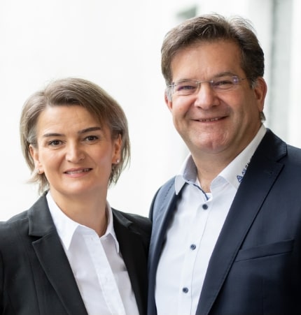 Team AS Bauer, Frau und Mann, lächelnd, in Business-Kleidung